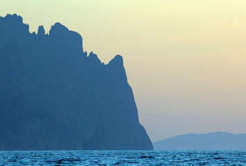 mountain cliffs along the shoreline of the sea.