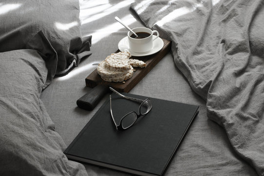 Breakfast and book in grey bed at sunlight