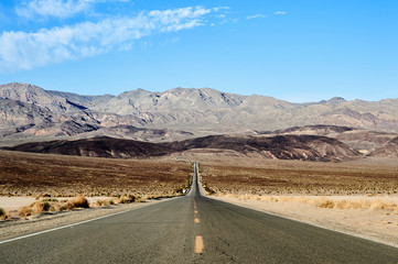 Long straight road leading to mountains in Death Valley, California
