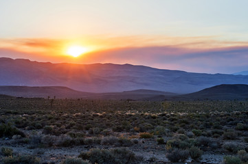 Sun setting behind mountains on a roadtrip in California