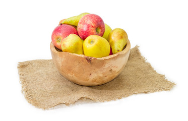 Apples and pears in vintage wooden fruit bowl on sackcloth