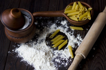 flour, pasta, rolling pin and spices on a wooden table