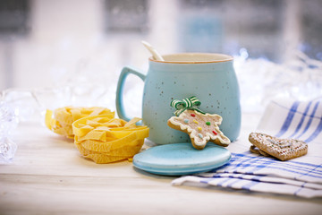 New Year's still life with an open sugar bowl, white spoon, cookies, pasta, tablecloth in a box on a white wooden table, bright background on a sunny day