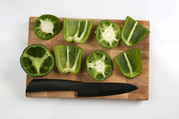 sliced sweet peppers with a ceramic knife on a wooden board
