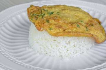 Omelet top on rice all in white plate