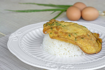 Omelet top on rice all in white plate
