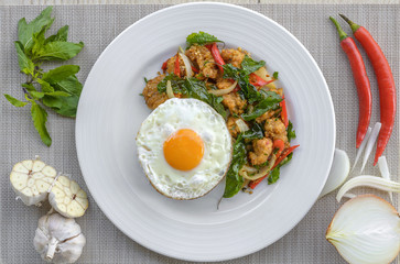 Crispy chicken cooked with sweet basil eat with rice and egg.it is a very delicious Thai food.