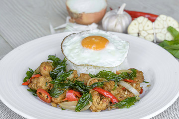 Crispy chicken cooked with sweet basil eat with rice and egg.it is a very delicious Thai food.