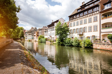 Fototapeta na wymiar Landscape view on the water channel with beautiful half-timbered houses in Strasbourg city, France