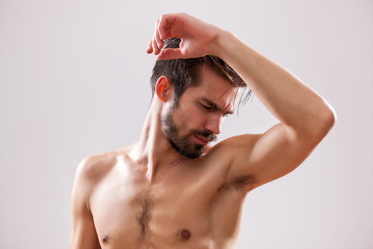 Young Man Is Smelling His Armpit Before Shower. 