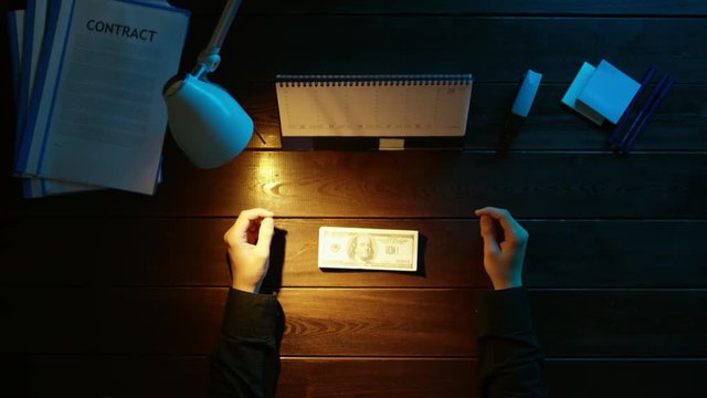 A man is sitting at an office desk and using a phone.