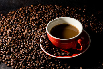 coffee in red cup and coffee beans are the background.