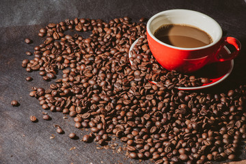 coffee in red cup and coffee beans are the background.