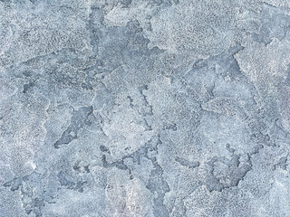 Old blue wall covered with uneven plaster. Texture of vintage shabby silver stone surface, closeup.