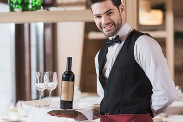Waiter holding tray with wineglasses and bottle