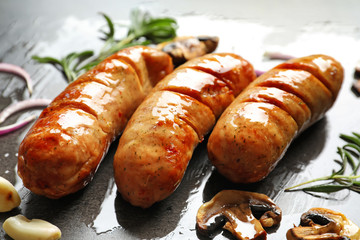 Grilled sausages on grey background