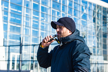 Young man smoking and electronic ciggarette