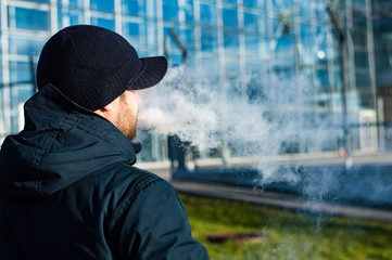 Young man smoking and electronic ciggarette