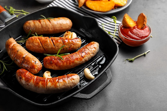 Grill pan with delicious grilled sausages on table