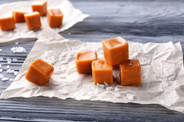 Salted caramel candies on wooden background