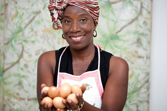 young smiling woman holding eggs in the hand