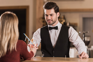 bartender giving cocktail to client
