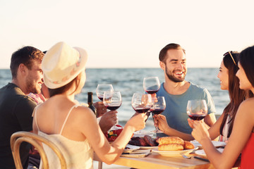 Young people having barbecue party on beach © Africa Studio