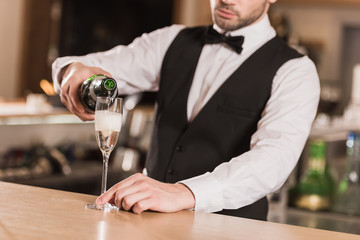 bartender pouring champagne into glass