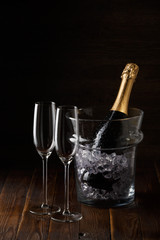 Image of wine glasses on wooden table with pail with ice