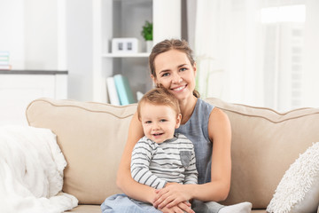 Mother with baby boy on sofa at home