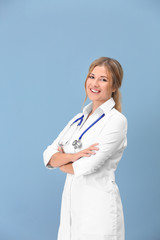 Doctor with stethoscope on color background