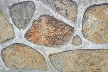 Old stone wall. Uneven rough stones of different shapes. Stone background. 