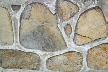 Old stone wall. Uneven rough stones of different shapes. Stone background. 