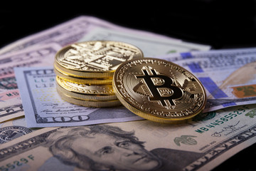 Golden bitcoin on dollar bills.