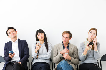 Sitting men and women using smart phone.