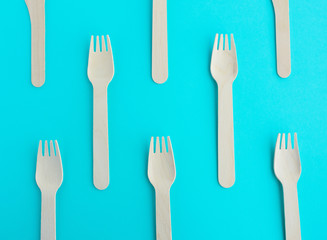 creative wooden recycled fork set on blue mint background top view pattern