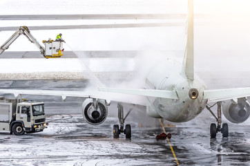 Ground crew provides de-icing. They are spraying the aircraft, which prevents the occurrence of...