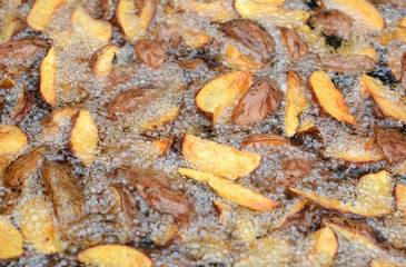 Fried potatoes frying in boiling oil. Preparation of fried potatoes in rural.