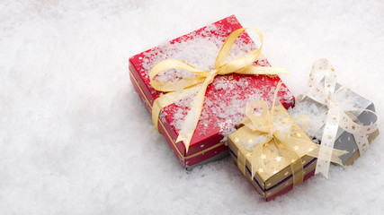 Merry Christmas and Holidays presents and gifts concept with a wrapped gift boxes on snow background with copy space