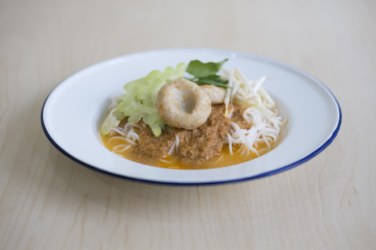 COCONUT CURRY WITH RICE NOODLE
Coconut fish curry with rice noodle served with white enamel plate. Popular thai street food. 