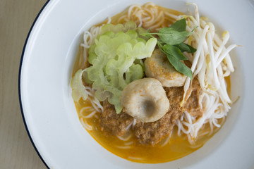 COCONUT CURRY WITH RICE NOODLE
Coconut fish curry with rice noodle served with white enamel plate. Popular thai street food. 
