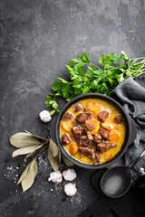 Meat stew, goulash in a cast iron pot, top view