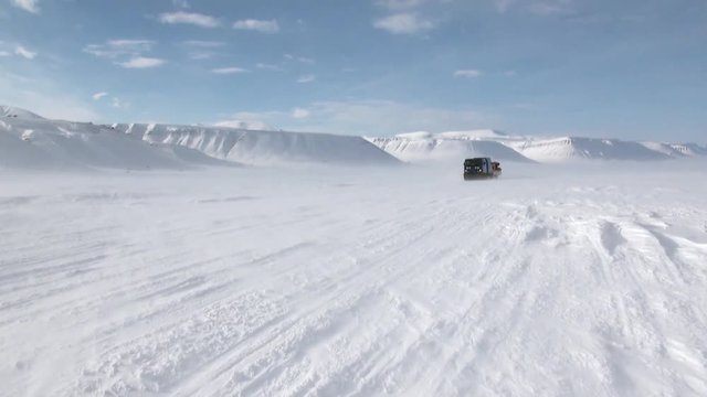 Cross-country vehicle in North Pole Spitsbergen Svalbard Arctic. Way from airport Longyear to Pyramiden on background of glacier.