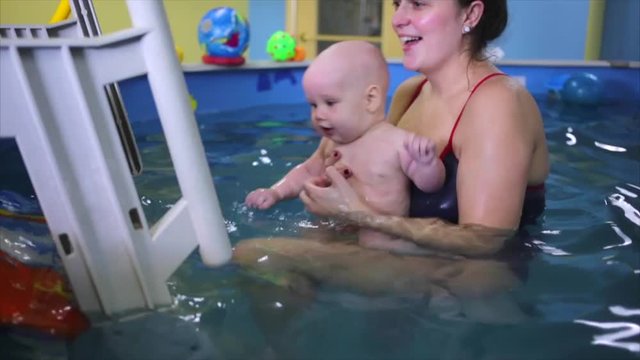 the child in the pool with the coach.