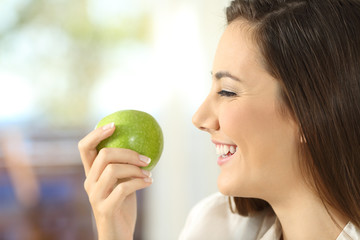 Profile of a woman holding an apple