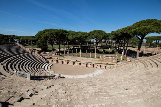 Almost complete Roman theater in Ostia antica. Drama place in ancient Rome with sea pines in background and ruins