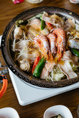 Nabe (Japanese hot pot dishes ) including prawns, salmon, pork, vegetables and mushrooms at the restaurant in Hokkaido, Japan.