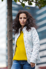 Portrait of a beautiful girl in an urban landscape in autumn