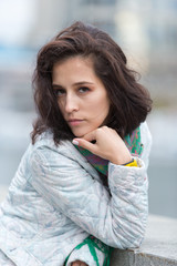 Portrait of a beautiful girl in an urban landscape in autumn