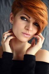 Fototapeta premium Portrait of a beautiful young red-haired woman with short hair